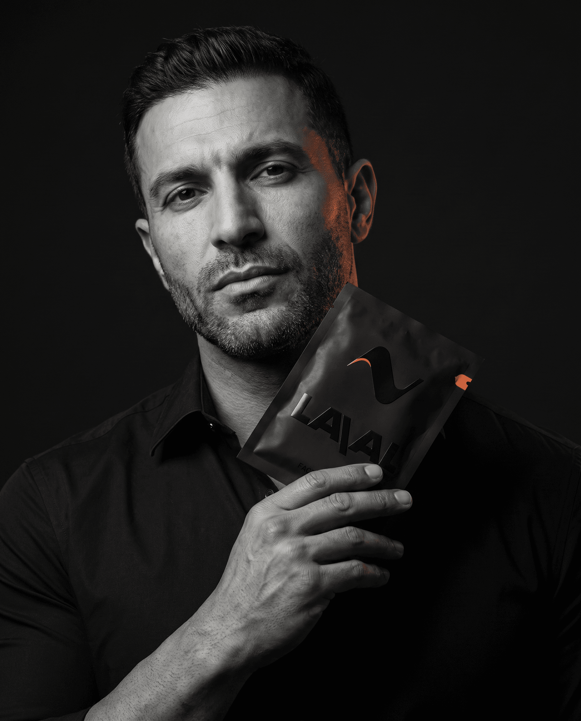 A well-groomed man holding a LAVAL foil sachet to his face