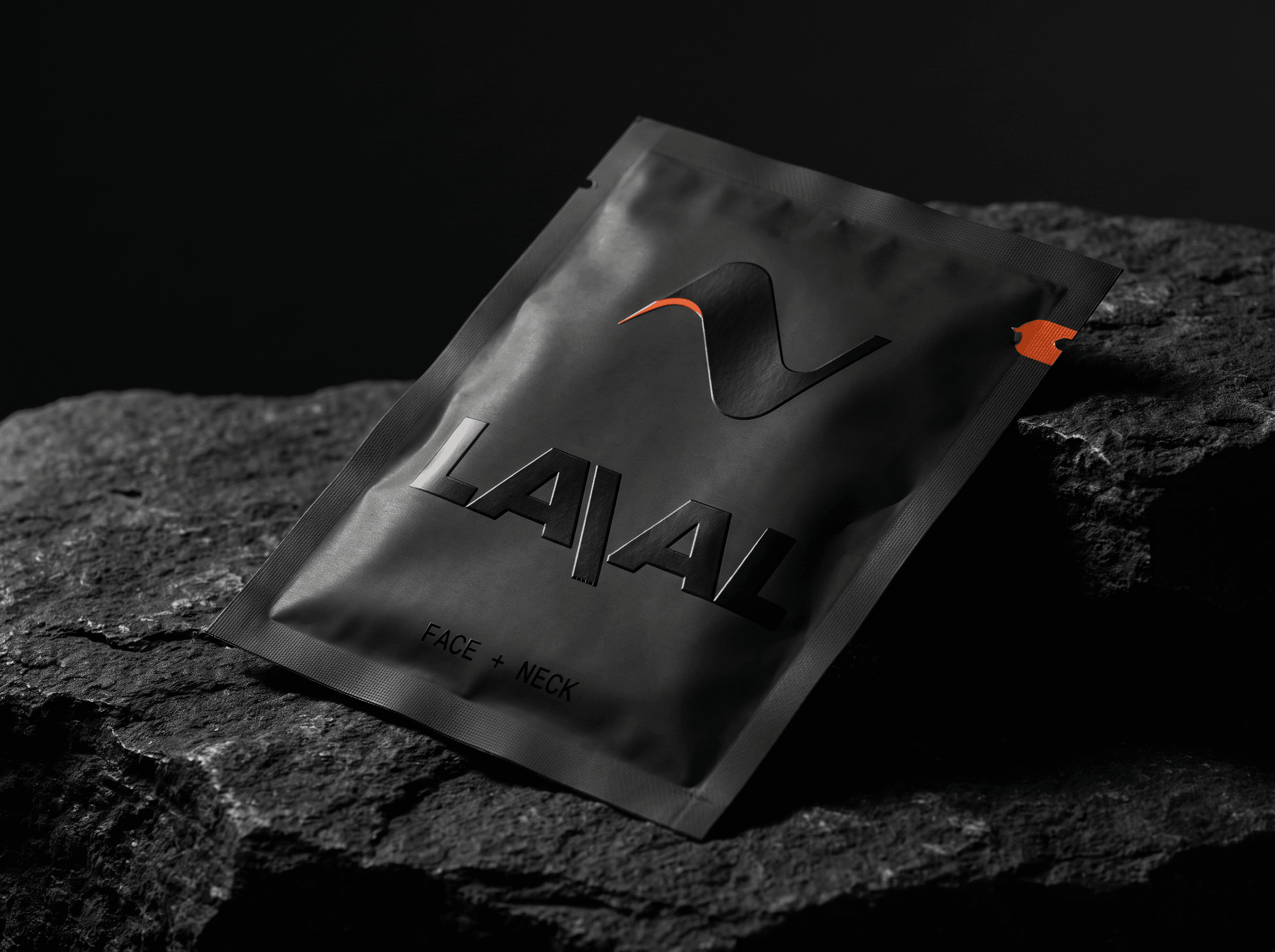 A matte-black LAVAL foil sachet with the ember tear-notch, on dark stone